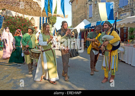 Musiker in mittelalterlichen Kostümen, spielen Tabors, Schalmeien, Drehleier und galizischen Dudelsack durch die Straßen des Dorfes Stockfoto