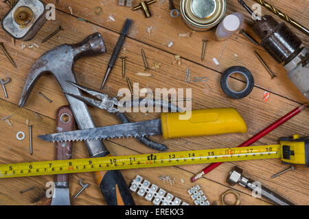 Pflege zu Hause - eine unordentliche Workshop Bank voller staubigen alten Werkzeuge und Schrauben. Stockfoto