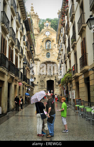 Touristen mit einem Reisen führen außerhalb Basilika der Heiligen Maria des Chores, San Sebastian, Spanien Stockfoto