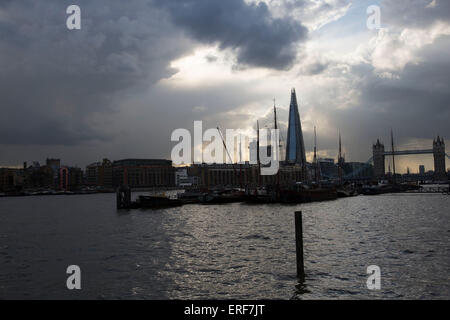 Die Scherbe drohend über Liegeplätze auf der Themse an bewölkten und stürmischen Tag in London, Vereinigtes Königreich.  Die Scherbe, auch genannt der Shard of Glass, Shard London Bridge und London Bridge Tower, früher ist eine 87-geschossiges Hochhaus in London Teil der London Bridge Quartal Entwicklung. Stockfoto