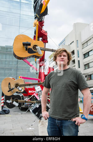 Stuttgart, Deutschland. 29. Mai 2015. Der britische Künstler William Hunt posiert vor dem Kunstmuseum in Stuttgart, Deutschland, 29. Mai 2015. Hinter ihm hängen Musikinstrumente aus einem Kran, Teil seiner Musik-Performance "Easy Listening, harte Arbeit". Foto: Wolfram Kastl/Dpa/Alamy Live-Nachrichten Stockfoto