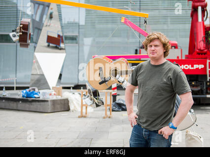 Stuttgart, Deutschland. 29. Mai 2015. Der britische Künstler William Hunt posiert vor dem Kunstmuseum in Stuttgart, Deutschland, 29. Mai 2015. Hinter ihm hängen Musikinstrumente aus einem Kran, Teil seiner Musik-Performance "Easy Listening, harte Arbeit". Foto: Wolfram Kastl/Dpa/Alamy Live-Nachrichten Stockfoto