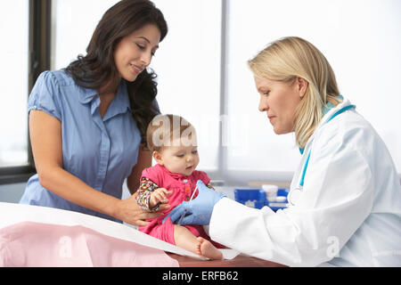 Arzt In der Chirurgie geben Baby Mädchen Injektion Stockfoto