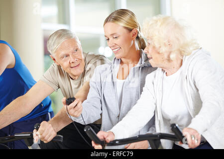 Messzeit für ältere Leute auf spinning Bikes im Fitness-Studio Fitness-trainer Stockfoto