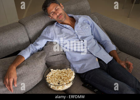 Hispanic Mann auf Sofa vor dem Fernseher eingeschlafen Stockfoto