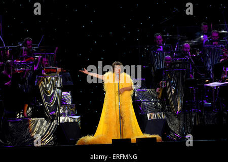 Shirley Bassey - walisische Sängerin erklingt in der Wembley Arena, London, UK, 9. Juni 2006. 8. Januar 1937, Dame Veronica Shirley Bassey. Gelbes Kleid tragen. Goldenen Verzierungen. Orchester im Hintergrund. James Bond-Verbindung. Stockfoto