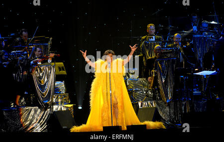 Shirley Bassey - walisische Sängerin erklingt in der Wembley Arena, London, UK, 9. Juni 2006. 8. Januar 1937, Dame Veronica Shirley Bassey. Gelbes Kleid tragen. Goldenen Verzierungen. Orchester im Hintergrund. James Bond-Verbindung. Stockfoto