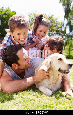 Familie entspannend im Garten mit Hund Stockfoto