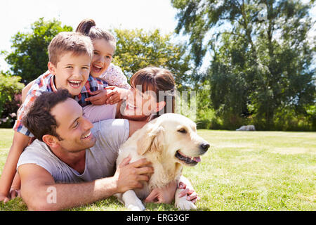 Familie entspannend im Garten mit Hund Stockfoto