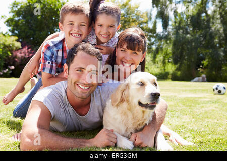 Familie entspannend im Garten mit Hund Stockfoto