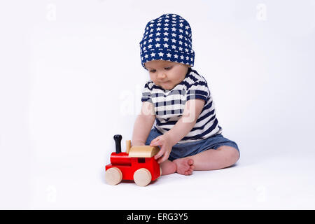 niedliche Baby spielt mit einem roten Zug Stockfoto