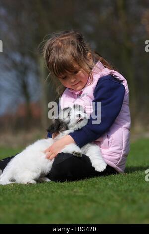 Kind mit Coton de Tulear Welpen Stockfoto