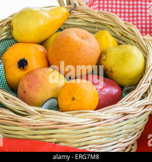 Orangen, Äpfel und Birnen in einem Weidenkorb Stockfoto