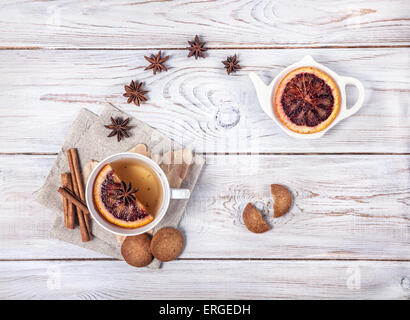 Marokkanischer Tee mit Gewürzen und Orangenscheibe auf dem weißen Hintergrund Holz Stockfoto