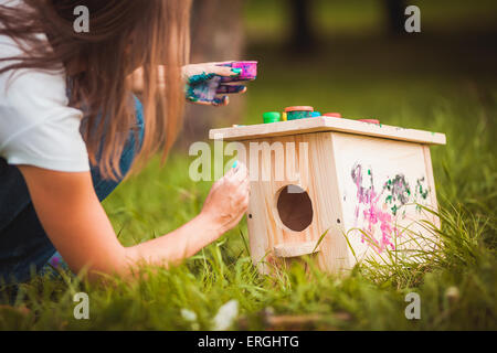 Mädchen malen Vogelhaus Stockfoto