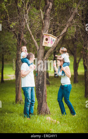 Glückliche Familie mit Holz Vogelhaus Stockfoto