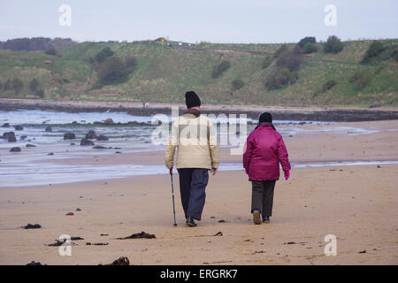 Älteres Ehepaar zu Fuß am Strand Stockfoto