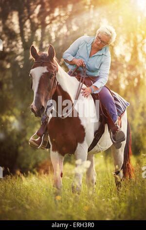 Frau reitet Pinto Stockfoto