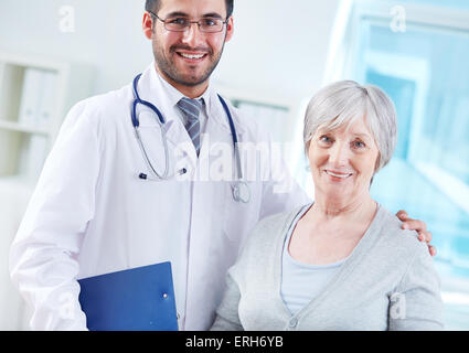 Glückliche junge Ärztin und ältere Patientin Stockfoto