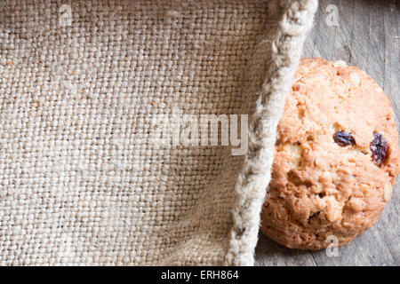 Hausgemachte Haferkekse auf einem alten Holztisch und Sackleinen, Platz für text Stockfoto