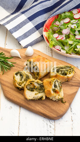 Teig Rollen Strudel mit Mangold und Chorizo auf Schneidebrett, junger Knoblauch mit Kopfsalat und Rucola Blätter Salat, gehackt Stockfoto