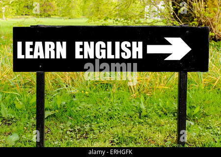 Lernen Sie Englisch mit Pfeil nach rechts gegen natürlichen grünen Hintergrund auf Schwarz Metall Richtungsanzeiger geschrieben. Stockfoto