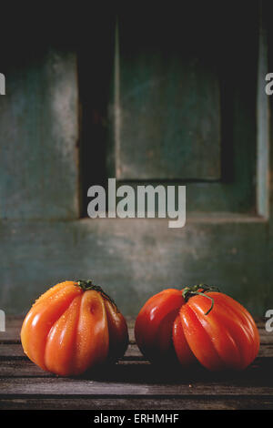 Zwei große rote Tomaten RAF über alten Holztisch. Dunkle, rustikale Atmosphäre Stockfoto