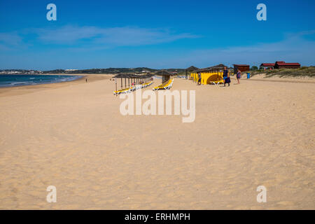 Liegestühle und Sonnenschirme auf einer fast leeren Strand warten auf die Sonnenanbeter kommen an den Strand Stockfoto