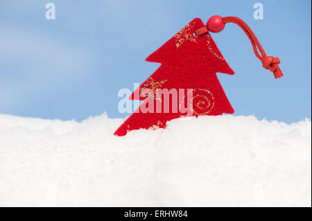 rot Weihnachtsspielzeug im Schnee gegen Himmel Stockfoto