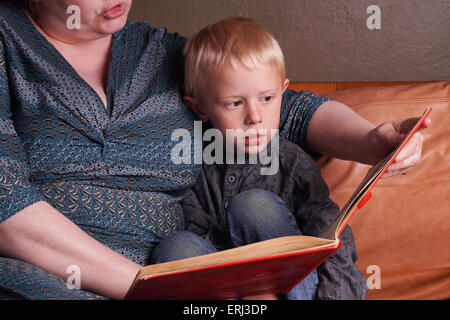 Geschichte Zeit auf der Couch, Frau liest das Buch, das kleine Kind Stockfoto