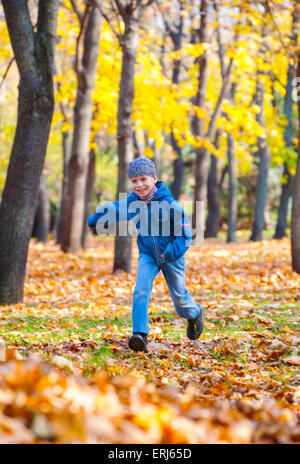 Junge läuft im Herbst-park Stockfoto