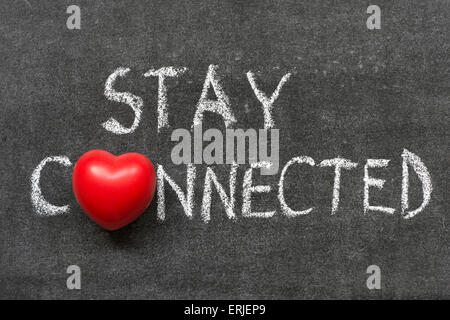 bleiben Sie in Verbindung-Satz handschriftlich auf Tafel mit Herzsymbol statt O Stockfoto