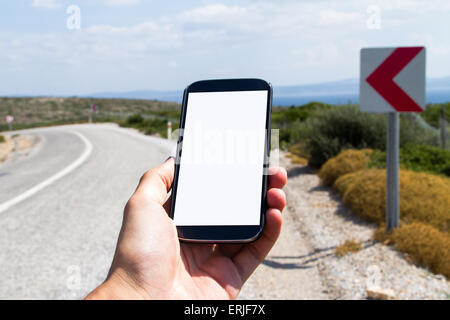 Hand halten und zeigen Smartphone mock-up mit leeren weißen Bildschirm mit textfreiraum unterwegs. Stockfoto