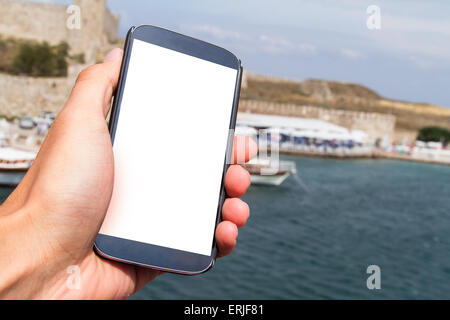Hand halten und zeigen Smartphone mock-up mit leeren weißen Bildschirm mit textfreiraum unterwegs. Stockfoto