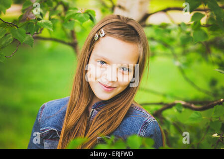 Porträt von Recht jugendlich Mädchen lächelnd und Blick in die Kamera. Kind im grünen Park. Nahaufnahme von niedlichen 12 Jahre altes Mädchen Stockfoto