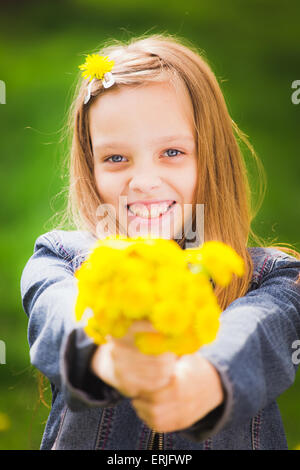 Nahaufnahme Portrait lächelnd junges Mädchen Blumenstrauß in Händen hält. Mädchen mit gelben Löwenzahn. Lächelndes Gesicht teenag Stockfoto