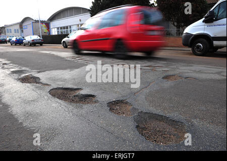 Straße mit großen Schlaglöchern und Autos Stockfoto