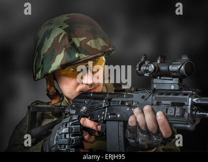 Junger hübscher Soldat (Scharfschütze) mit dem Ziel, einer Maschinengewehrs Stockfoto