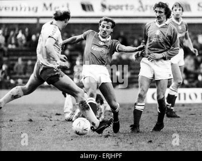 Birmingham City Fußballer Robert Hopkins in Aktion von Nowrich City-Spieler Greg Downs als Des Bremner herausgefordert blickt auf in ihrer Wiedergabe von FA Pokalspiel in St Andrews. Januar 1985. Stockfoto