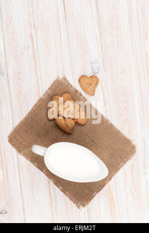 Herzform Lebkuchen und Milch Krug. Auf weißer Holztisch Stockfoto