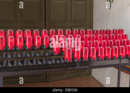 Votiv-Kerzen bei "Mission San Juan Capistrano" mit Ruinen, Museum und Rehabilitation im Gange. Stockfoto