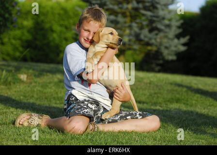 Junge mit Labrador-Retriever-Welpe Stockfoto