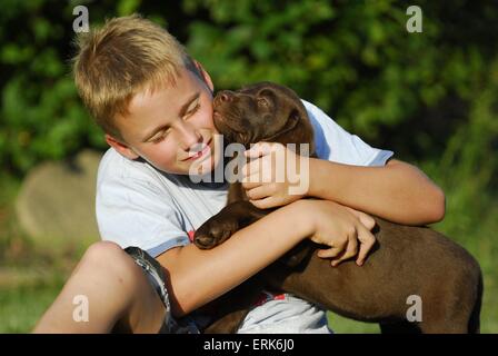 Junge mit Labrador-Retriever-Welpe Stockfoto