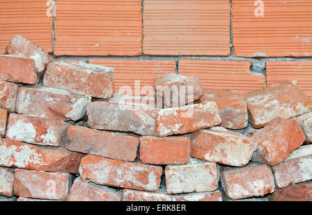 Nahaufnahme der alten gebrochen Ziegeln und Wand aus neuen roten Ziegeln Stockfoto