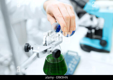 Nahaufnahme der Wissenschaftler füllen Reagenzgläser im Labor Stockfoto