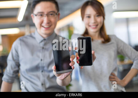 IT-Mitarbeiter zeigen Smartphone im Büro Stockfoto