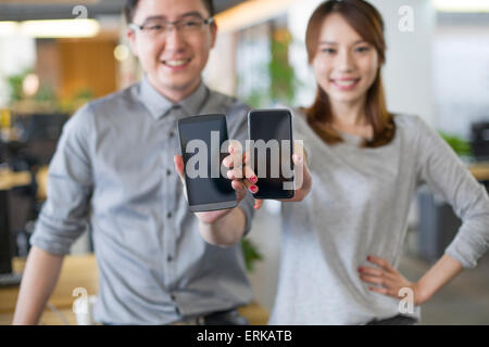 IT-Mitarbeiter zeigen Smartphone im Büro Stockfoto