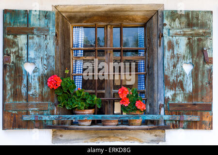 Fenster eines alten Bauernhauses geschmückt mit Geranien, Salzburger Land, Österreich Stockfoto