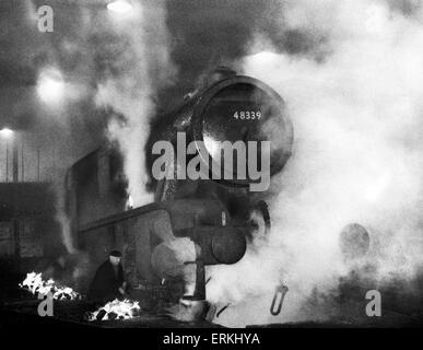 Ein London Midland & Scottish Railway Klasse 8F-Stanier Lok Motor wird durch das Anzünden der Kohle de-Eistee feuert auf Saltley Motor Schuppen um ihn herum. Januar 1963. Stockfoto