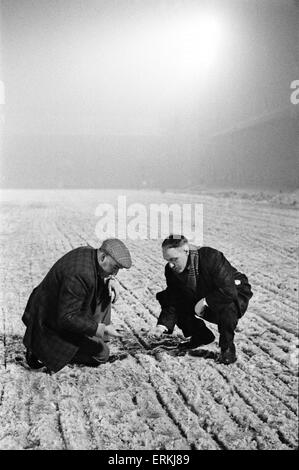 Liverpools Trainer rief Bill Shankly in Herrn John Flut von Queensferry, Experte für Boden bauen, um den Boden für Mittwoch die Krawatte Wiederholung Pokalspiel gegen den FC Burnley bereit. Hier ist er neben dem Traktor gezogen Scheibe Harrower durchschneiden die vereisten Tonhöhe an der Anfield Road abgebildet. Dies löst das Eis, bevor es von einem Bulldozer aufgehoben ist. 27. Januar 1963. Stockfoto